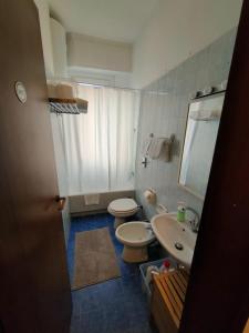 uma casa de banho com 2 WC, um lavatório e um espelho. em Short rent milan em Milão