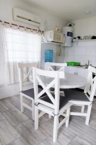 cocina con mesa blanca y 2 sillas en Leosanmareta en 