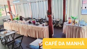 a room with two tables and chairs with at Falcon Hotel in Bauru