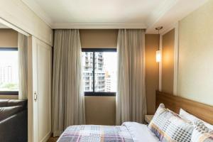 um quarto com uma cama e uma janela grande em Kaza Noah The Universe Paulista Bela Vista em São Paulo