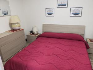 a bedroom with a bed with a pink comforter at La Dependance in Centro in Follonica