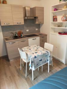 a kitchen with a table and chairs in a kitchen at La Dependance in Centro in Follonica
