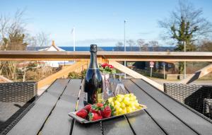 - une bouteille de vin et une assiette de fruits sur une table dans l'établissement Heidis Residence-Sandkaas, Bornholm, à Allinge