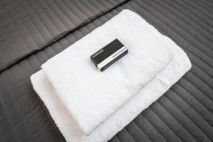 a remote control sitting on a white towel on a bed at Plantage Garden Apartments in Amsterdam +64 photos