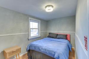a bedroom with a bed with a blue comforter and a window at about 20 Mi to Manhattan Quaint Clifton Home! in Clifton +18 photos