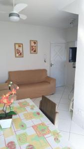 ein Wohnzimmer mit einem Tisch und einem Sofa in der Unterkunft Prédio Frente Para o Mar na Praia Grande - Guilhermina in Praia Grande
