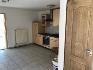 une cuisine avec des armoires en bois et un four à plaques de cuisson dans l'établissement Feel Natural and Relaxed in a 3 Bedroom Apartment in Gyongyosfalu, à Gyöngyösfalu