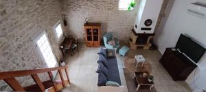 a living room with a couch and a tv at Gîte Maelga in Cartelègue