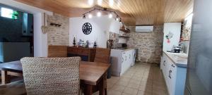 eine Küche mit einem Tisch und einem Esszimmer in der Unterkunft Gîte Maelga in Cartelègue
