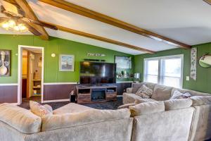 a living room with two couches and a flat screen tv at Port Clinton House with Boat Dock on Portage River! in Port Clinton