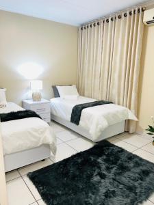 1 dormitorio con 2 camas y ventana en Isibani luxury apartment, en Richards Bay