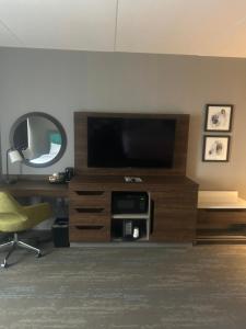 a living room with a television and a chair at Hampton Inn By Hilton Kingston in Kingston