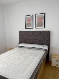1 cama en una habitación con 2 cuadros en la pared en RockSide Residences Suites La Línea N4 en La Línea de la Concepción