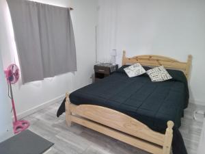 ein Schlafzimmer mit einem Holzbett und einer schwarzen Decke in der Unterkunft Leosanmareta in Badeort Reta