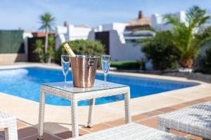 una mesa con gafas y un cubo junto a una piscina en Villa Rubi 19 Golf Private Pool Caleta de Fuste By Holidays Home, en Caleta de Fuste