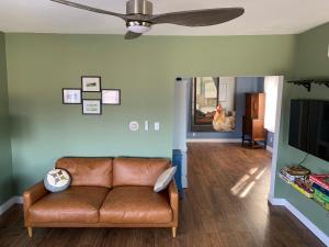 sala de estar con sofá y ventilador de techo en Vineyard Farmhouse with Hot Tub & Lake Views en Hammondsport