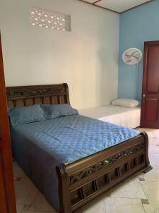 a bedroom with a bed with blue sheets and a window at Casa Hotel Arcadia Minca in Minca