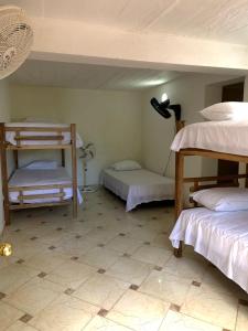 a room with two bunk beds and a tiled floor at Casa Hotel Arcadia Minca in Minca