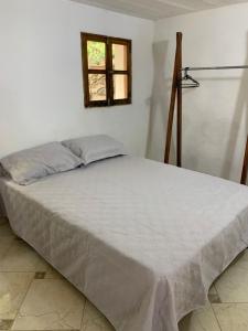 a white bed in a room with a window at Casa Hotel Arcadia Minca in Minca