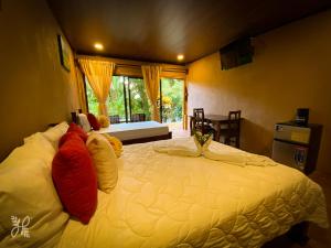 a large white bed in a room with a window at Hotel Heliconias Nature Inn & Hot Springs in Fortuna