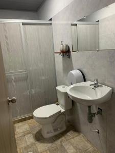 een badkamer met een toilet en een wastafel bij Los Potrillos in Mariquita