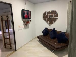 een woonkamer met een bank en een tv bij Los Potrillos in Mariquita