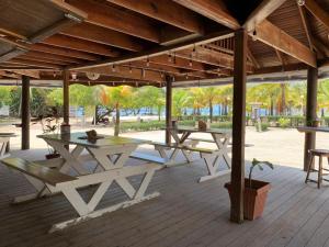 two picnic tables under a pavilion on a deck at Sea Eye Hotel - Tropical Building in Utila