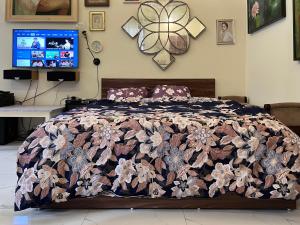 um quarto com uma cama com um edredão floral em The First Ba Trieu Ha Noi em Hanói