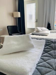 a bedroom with two beds with white towels on them at Polku Hotelli in Vihti