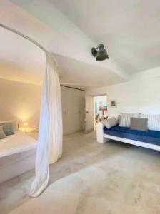 1 dormitorio con 1 cama y 1 sofá azul en Authentic Kea island house, en Otziás