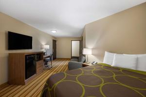 a hotel room with a bed and a flat screen tv at Super 8 by Wyndham O Neill NE in O'Neill