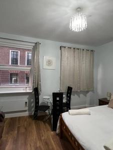 a bedroom with two beds and a window and a chandelier at 020- S3 Excellent central location in Paddington in London