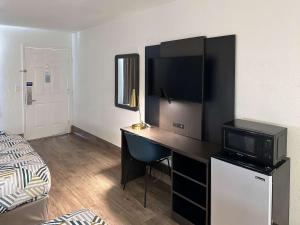 a bedroom with a desk with a television and a bed at Motel 6-Pooler, GA - Savannah Airport in Savannah