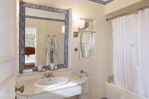 La salle de bains blanche est pourvue d'un lavabo et d'un miroir. dans l'établissement As Janelas Verdes Inn - Lisbon Heritage Collection - Riverside, à Lisbonne
