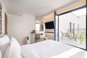 a bedroom with a bed and a view of a balcony at Hotel Yac Paris Clichy, a member of Radisson Individuals in Clichy