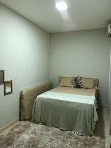 a bedroom with a bed in a white room at Casa privado com 3 quartos e piscina in Logradouro