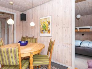 a dining room with a wooden table and chairs at 9 person holiday home in Grenaa in Grenå