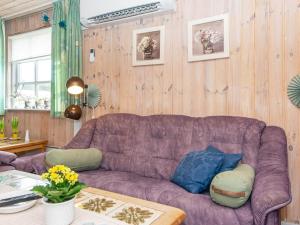 sala de estar con sofá púrpura y mesa en 9 person holiday home in Grenaa en Grenå