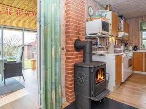 a kitchen with a wood stove in a room at 9 person holiday home in Grenaa in Grenå