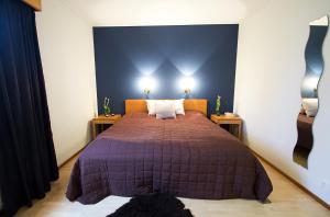 a bedroom with a purple bed with two night stands at Havsbandet Pensionat in Eckerö
