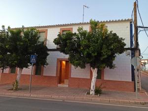 ein Gebäude auf einer Straße mit Bäumen davor in der Unterkunft Casa Rural Patio in La Puebla de los Infantes