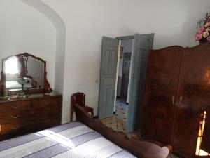 Schlafzimmer mit einem Bett, einer Kommode und einem Spiegel in der Unterkunft Casa Rural Patio in La Puebla de los Infantes