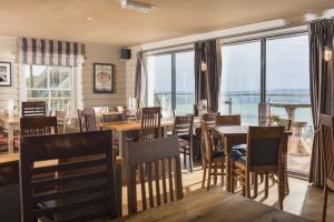 a restaurant with tables and chairs and large windows at Hope & Anchor in Hope Cove