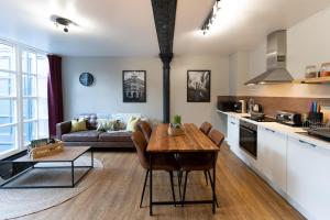 una cucina e un soggiorno con tavolo e divano di High Street Town House a Manchester