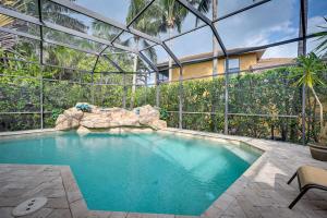 uma piscina numa casa com uma parede de vidro em Upscale Marco Island Home with Pool, 1 Mi to Beach em Marco Island