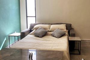uma cama com duas almofadas num quarto em Via 31 Departamentos Valladolid em Valladolid