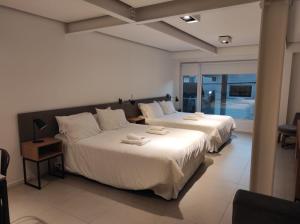 2 camas en una habitación con ventana en Aunaisin-Austral 101 en Ushuaia