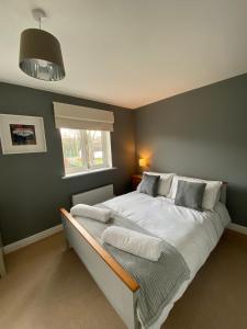 a bedroom with a large white bed with a window at Malmesbury 3 Bedroom Town House in Malmesbury
