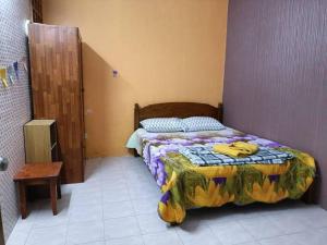 a bedroom with a bed with a comforter on it at AlFateh Homestay Kepala Batas in Kepala Batas