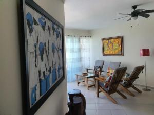 a living room with chairs and a painting on the wall at Your Little Paradise - Juan Dolio in Juan Dolio